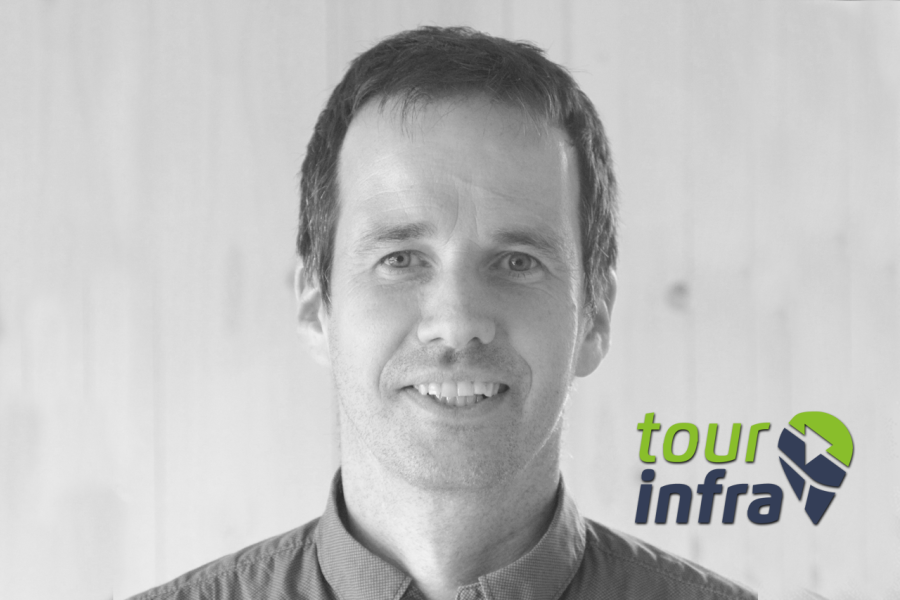 Smiling man in a shirt with the Tour Infra logo in the lower-right corner.