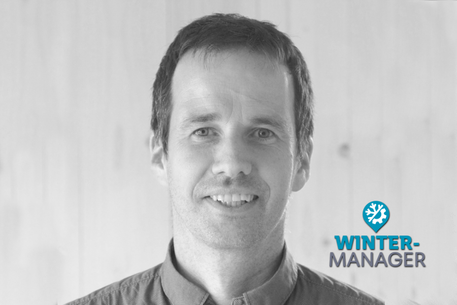 rainer_bw_wintermanager Smiling man in a collared shirt with a Winter-Manager logo in the lower right corner.